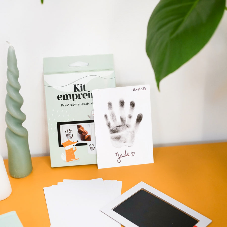 Kit d'empreinte de bébé avec détails des empreintes sur fond clair.