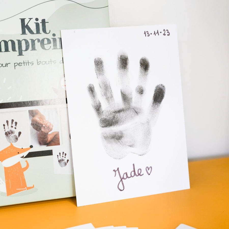 Kit d'empreinte de bébé avec détails des empreintes sur fond clair.