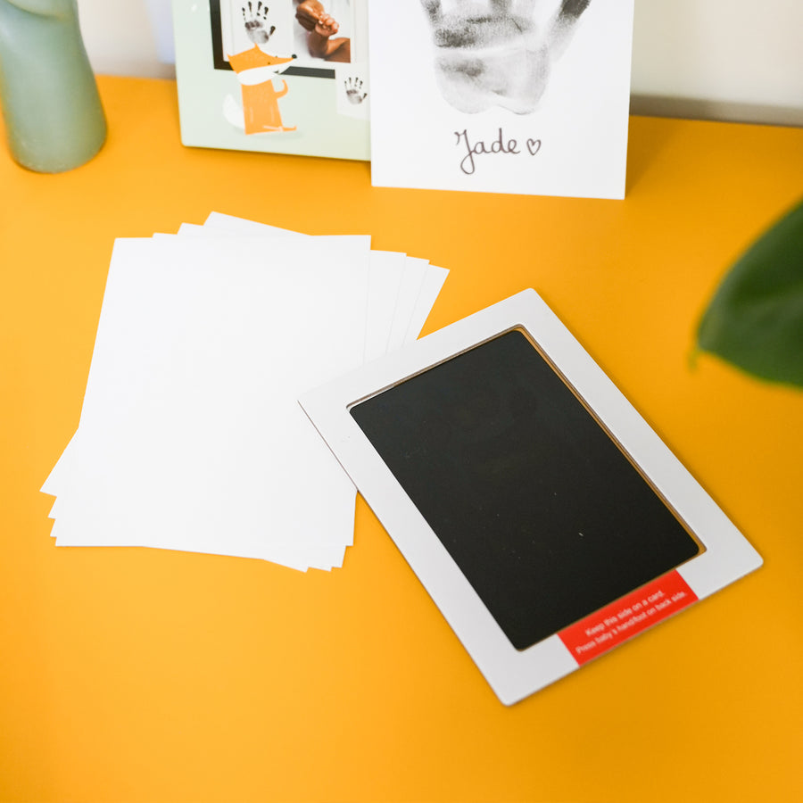 Kit d'empreinte de bébé avec détails des empreintes sur fond clair.