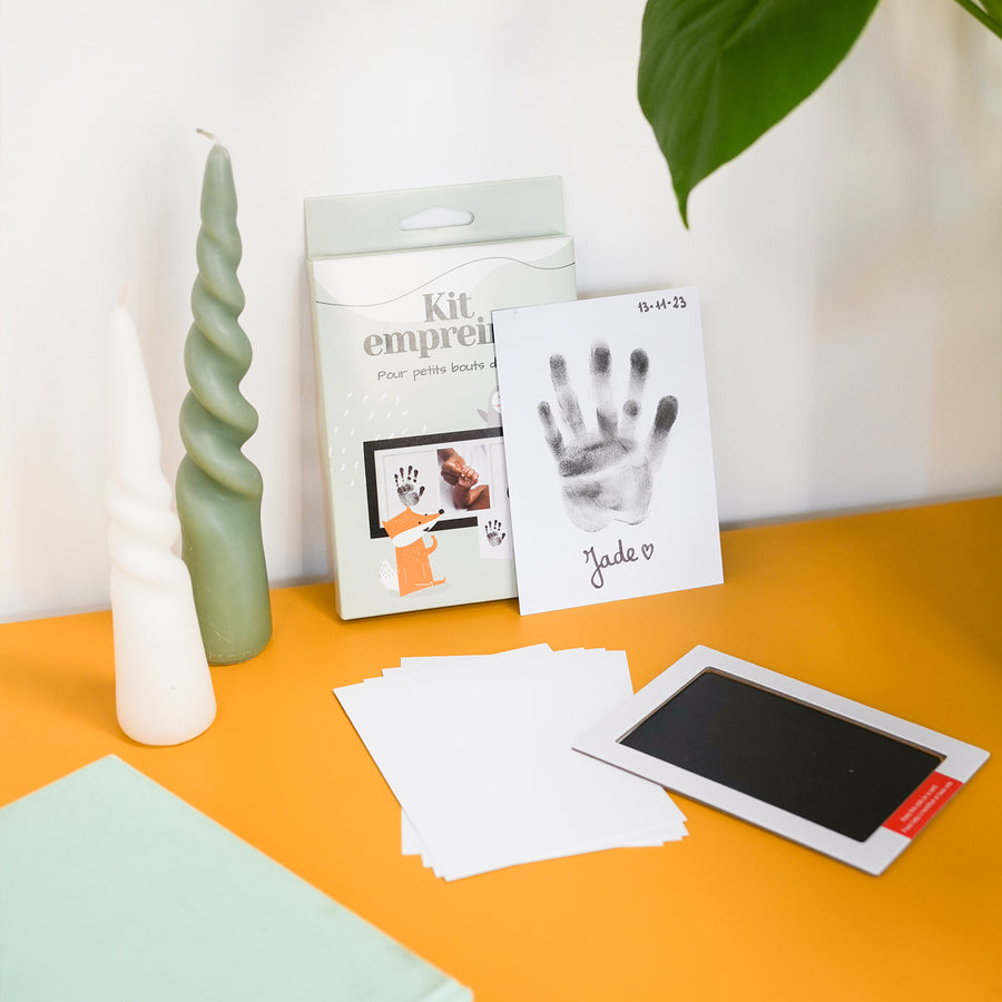 Kit d'empreinte de bébé avec détails des empreintes sur fond clair.