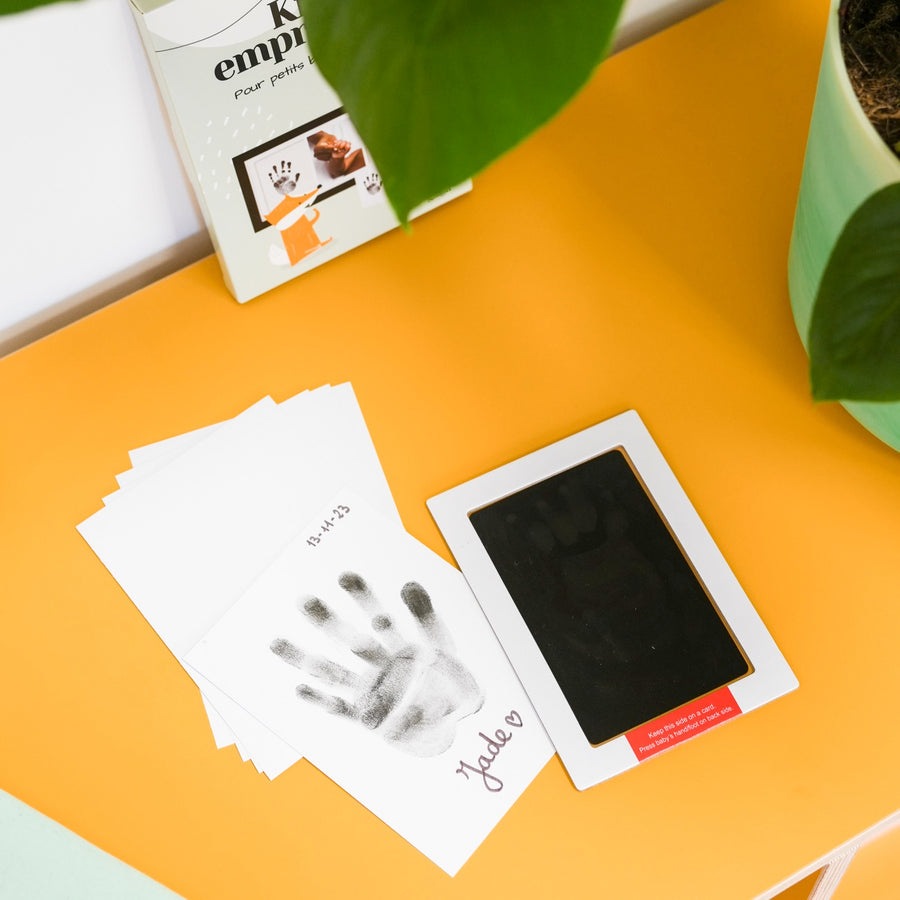 Kit d'empreinte de bébé avec détails des empreintes sur fond clair.