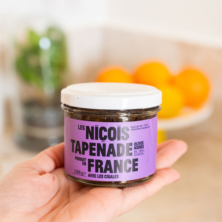 Pot de tapenade noire avec texture crémeuse et olives visibles.