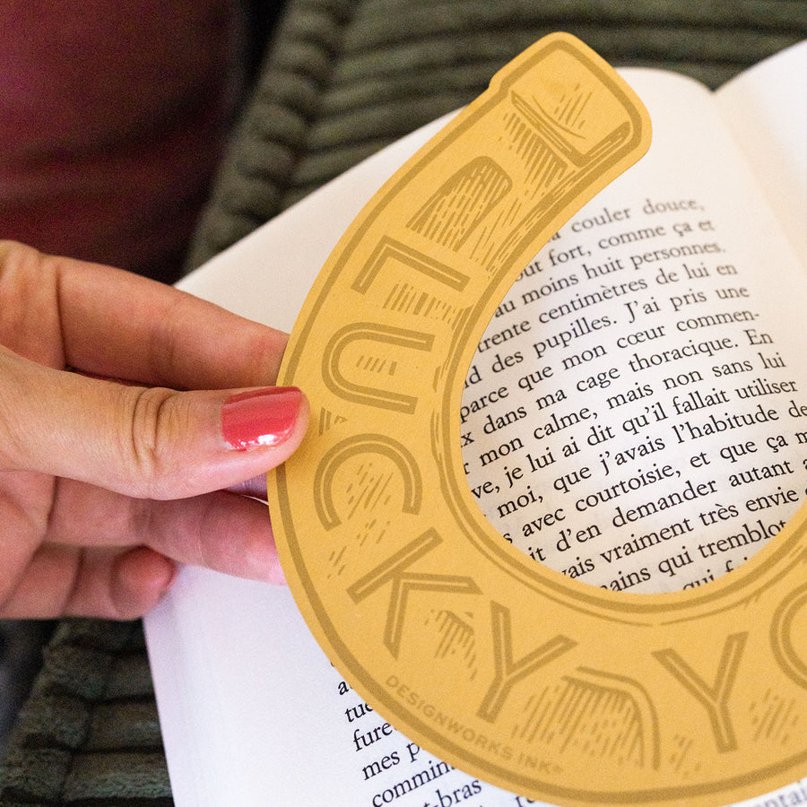 Marque-page en laiton en forme de fer à cheval, vue de côté.