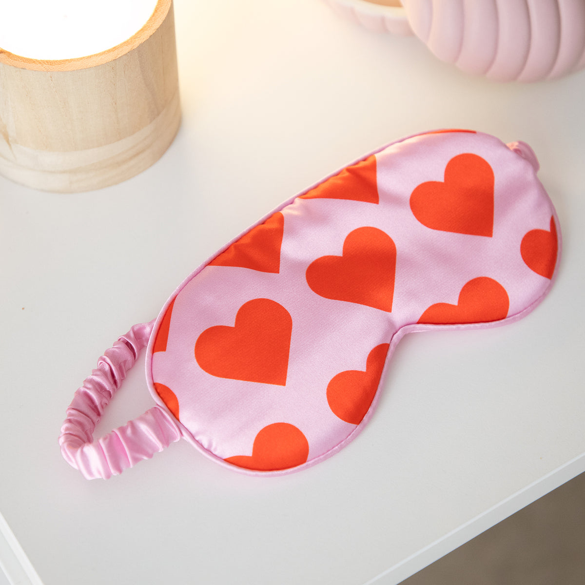 Masque de sommeil rose avec motifs de cœurs sur fond clair