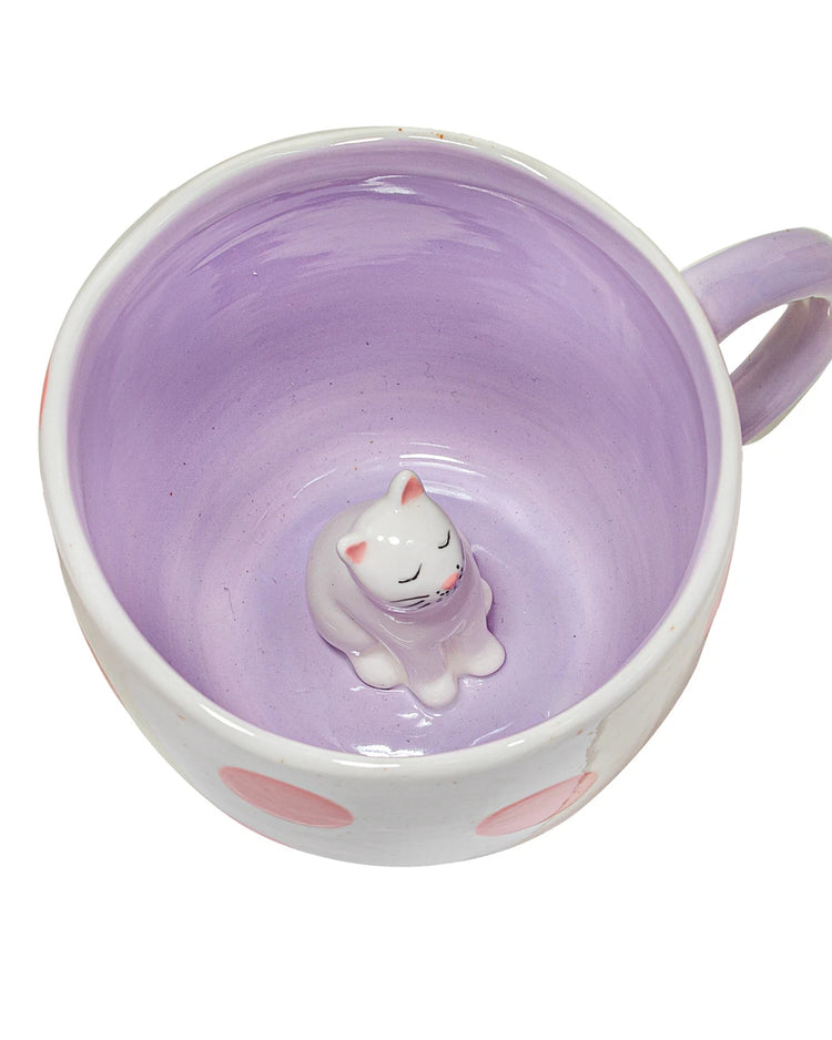 Mug rose et blanc avec un chat caché à l'intérieur