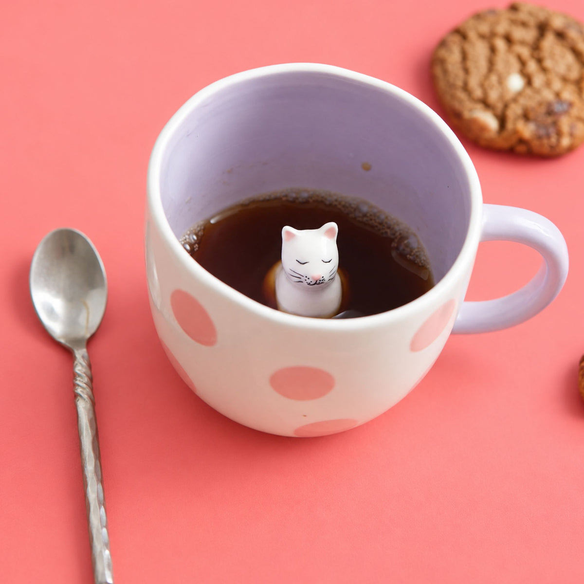 Mug rose et blanc avec un chat caché à l'intérieur
