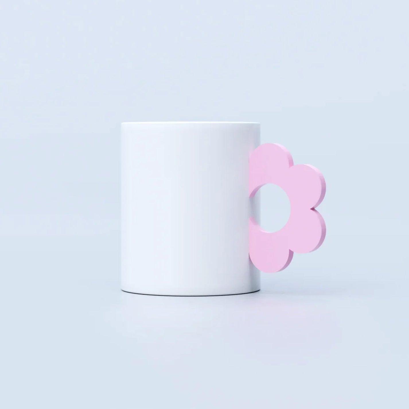 Mug en céramique avec motif floral et anse rose pastel.