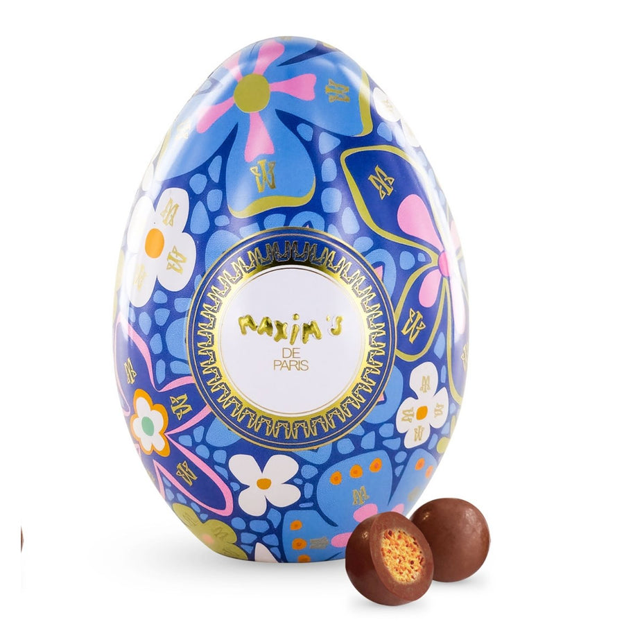 Oeuf Maxim's enrobé de chocolat au lait sur fond bleu