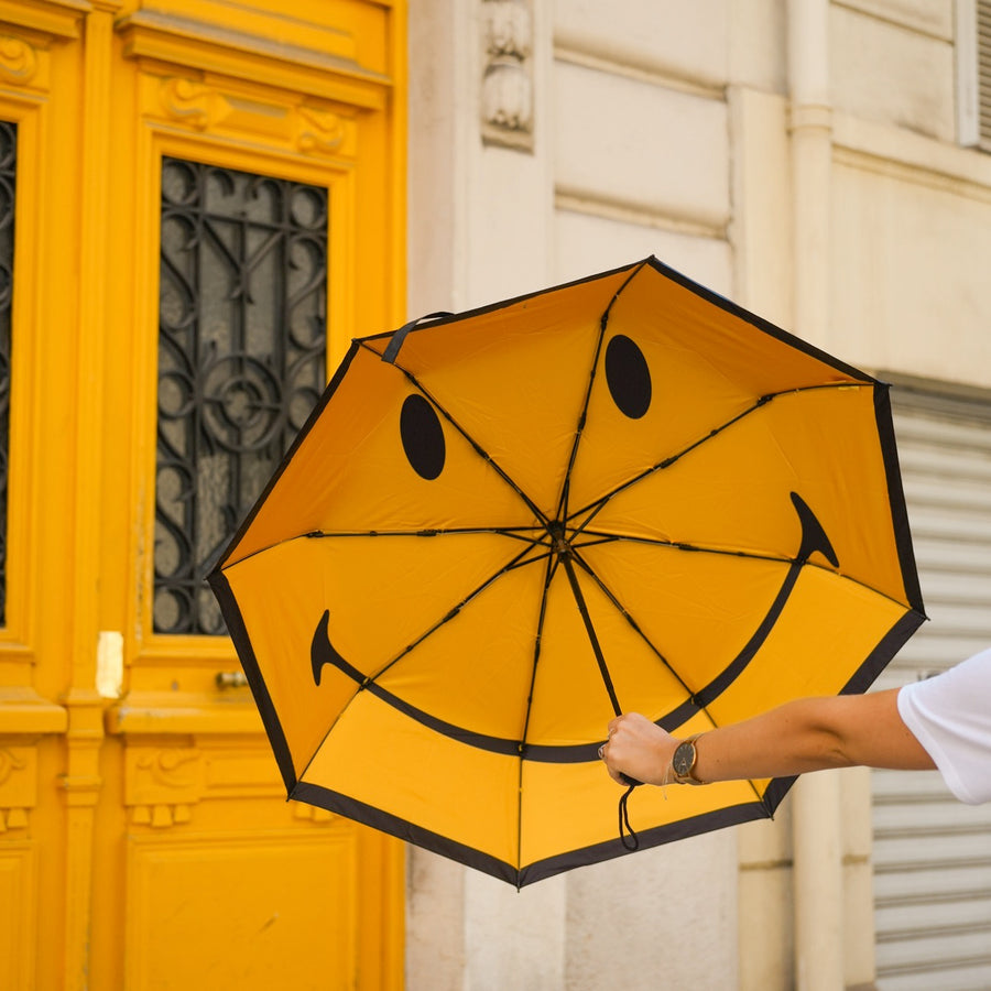 Parapluie Smiley ouvert, motif joyeux à l'intérieur.