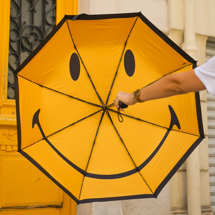 Parapluie Smiley ouvert, motif joyeux à l'intérieur.