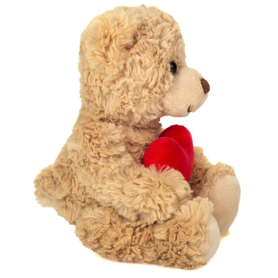 Ourson en peluche tenant un cœur rouge entre ses pattes