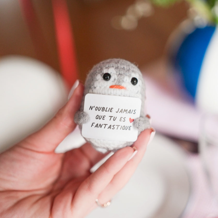 Peluche pingouin en crochet avec message inspirant sur le ventre.