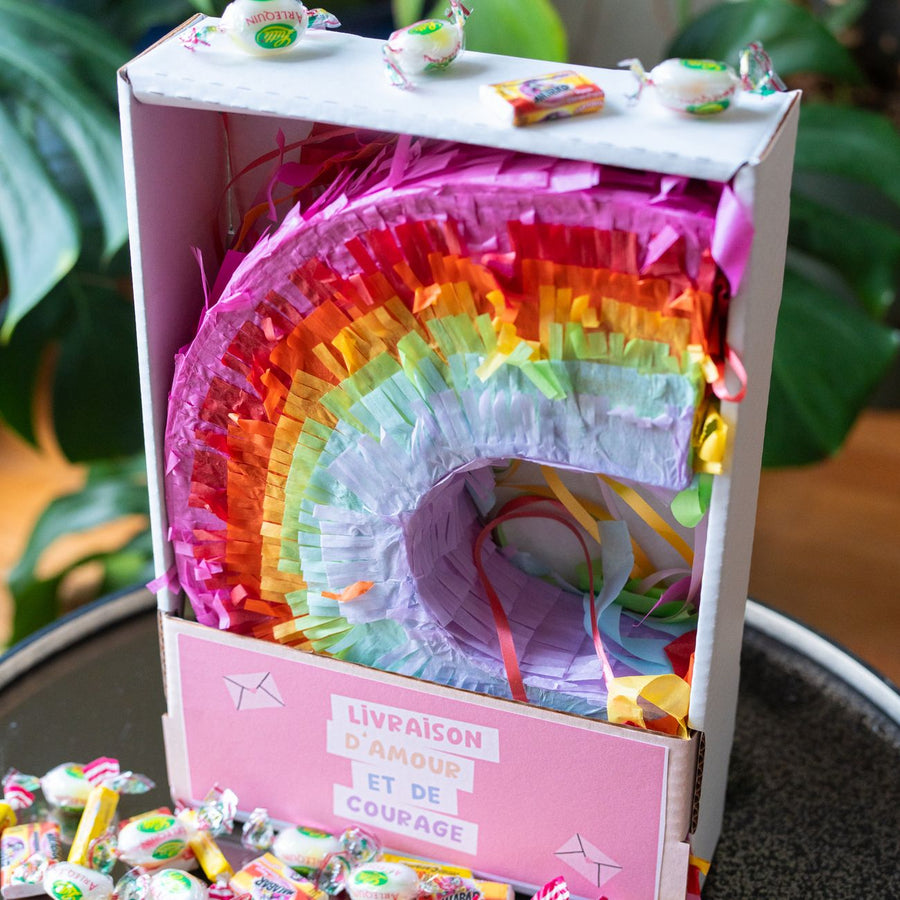 Piñata arc-en-ciel vue de côté, remplie de bonbons colorés.