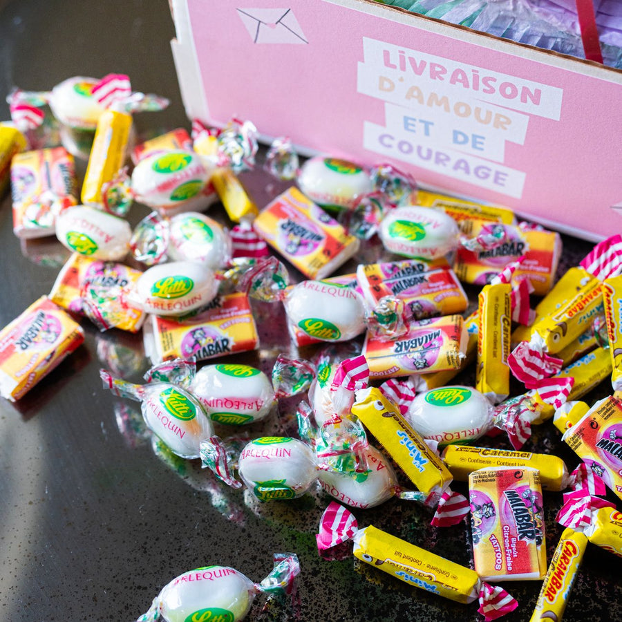 Piñata arc-en-ciel vue de côté avec bonbons colorés visibles.