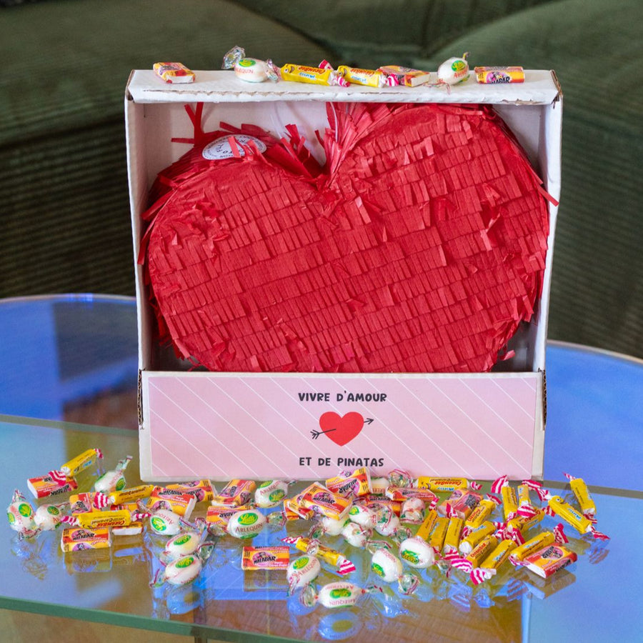 Piñata en forme de cœur remplie de bonbons colorés.
