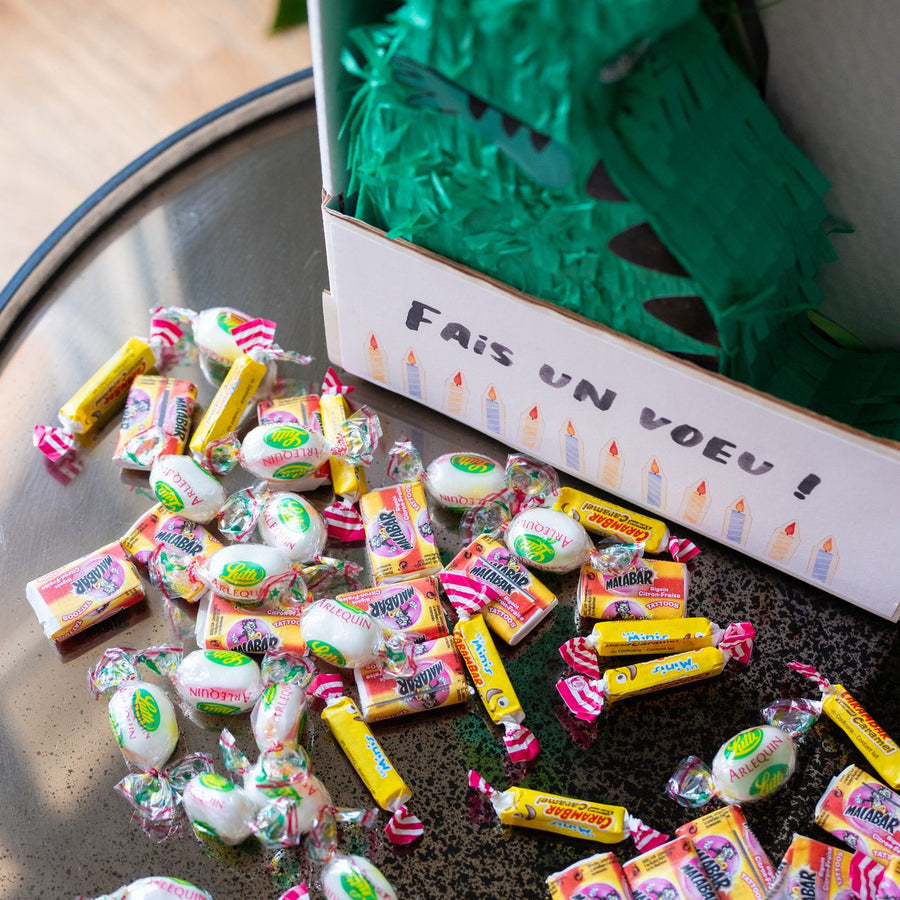 Piñata dinosaure colorée avec bonbons, vue de côté.