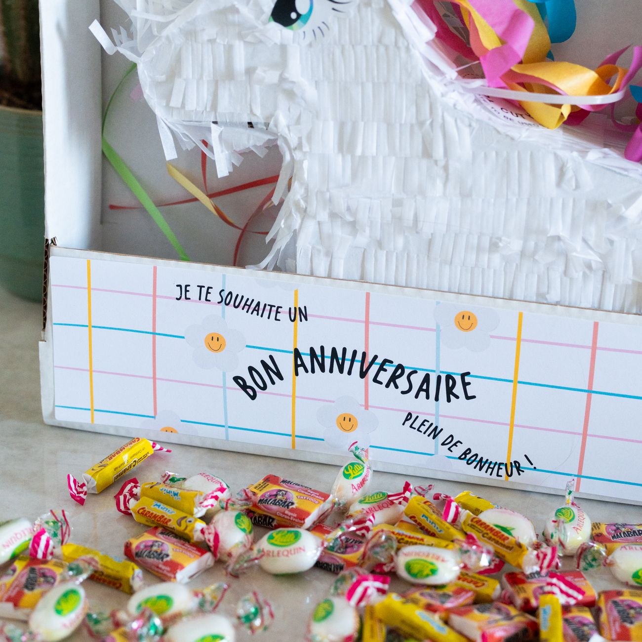 Piñata licorne colorée avec bonbons, vue de face.