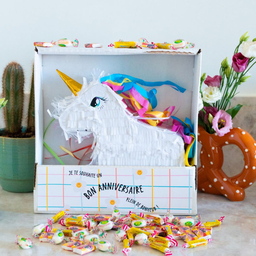 Piñata licorne colorée avec bonbons, vue de côté.