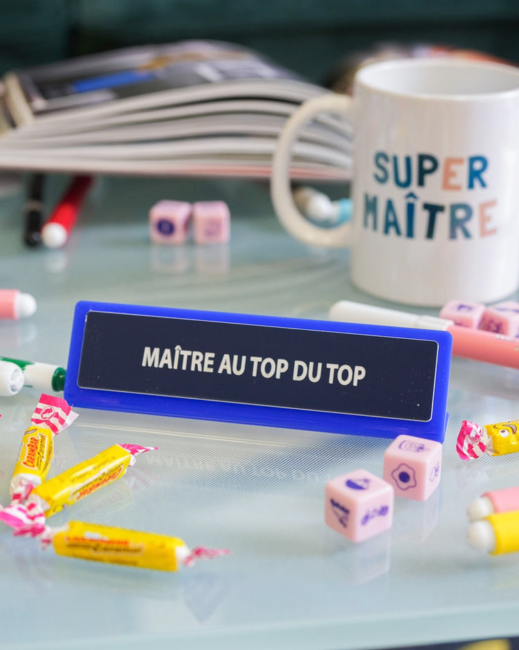 Plaque de bureau humoristique avec texte coloré sur fond clair.