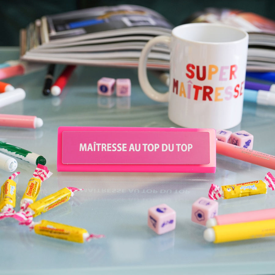 Plaque de bureau humoristique avec texte coloré sur fond clair.