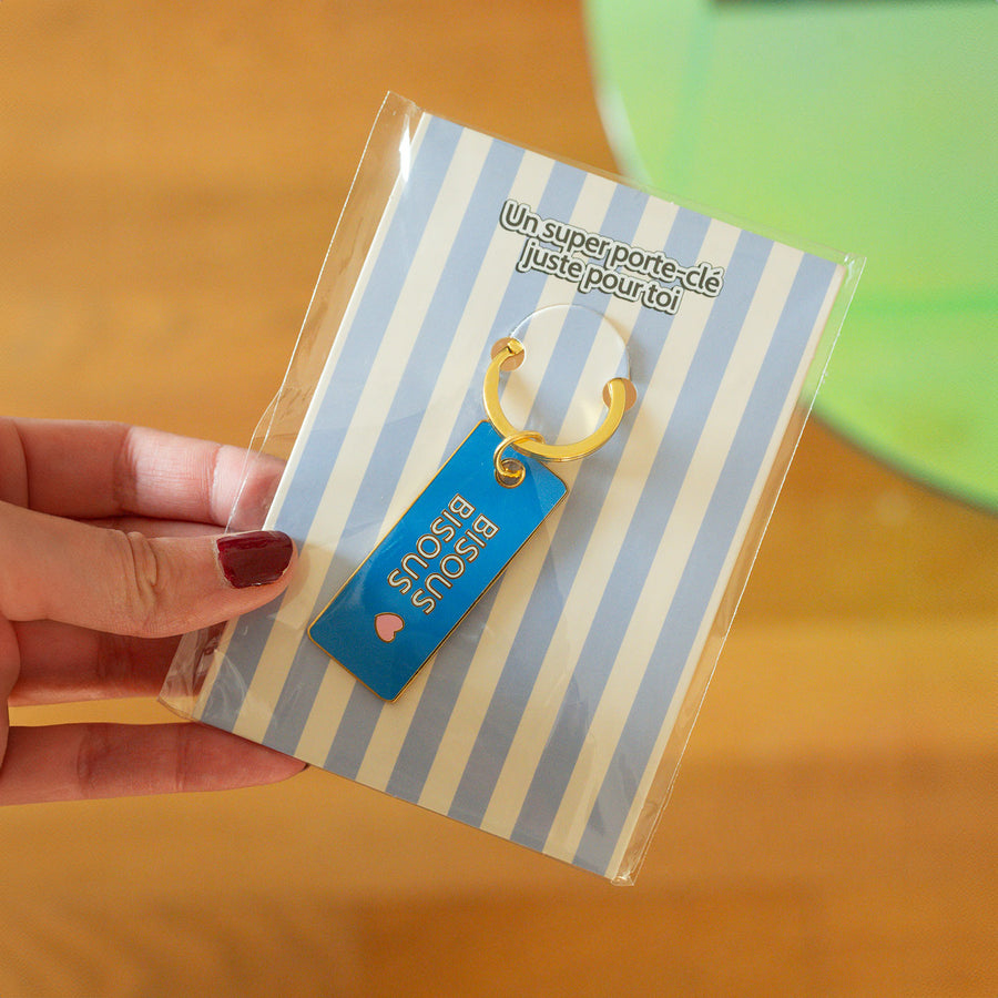 Porte-clé Bisous bisous avec cœur en relief et détails colorés.