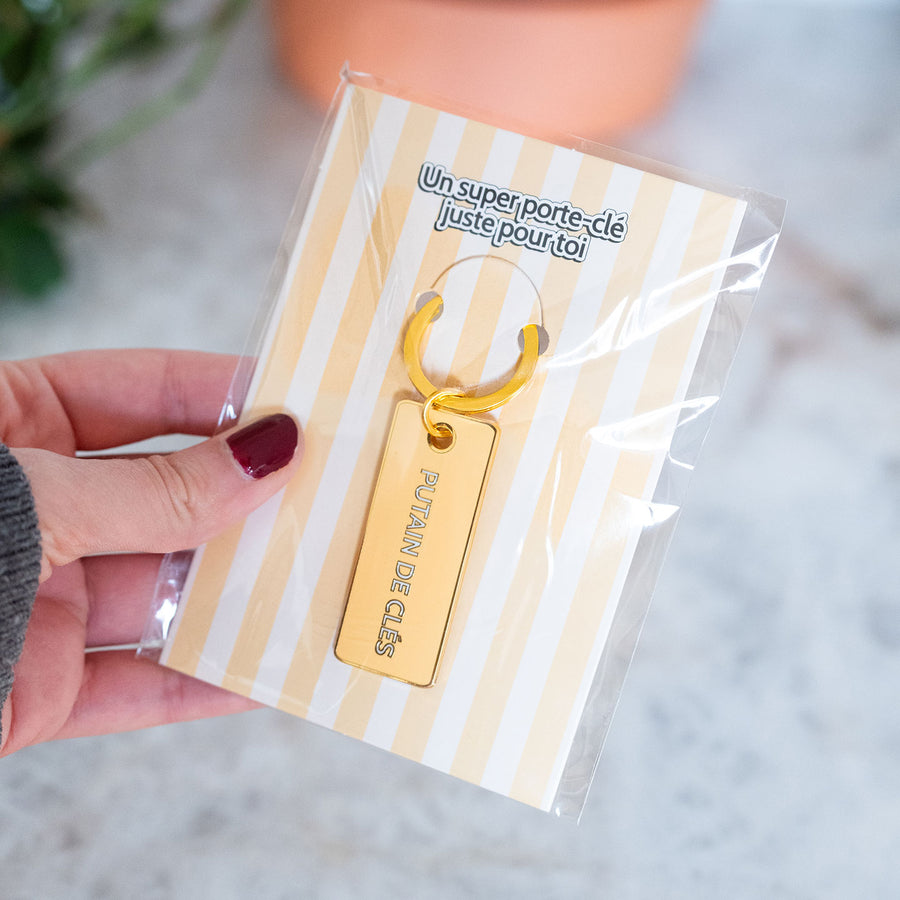 Porte-clé avec inscription humoristique sur fond clair.