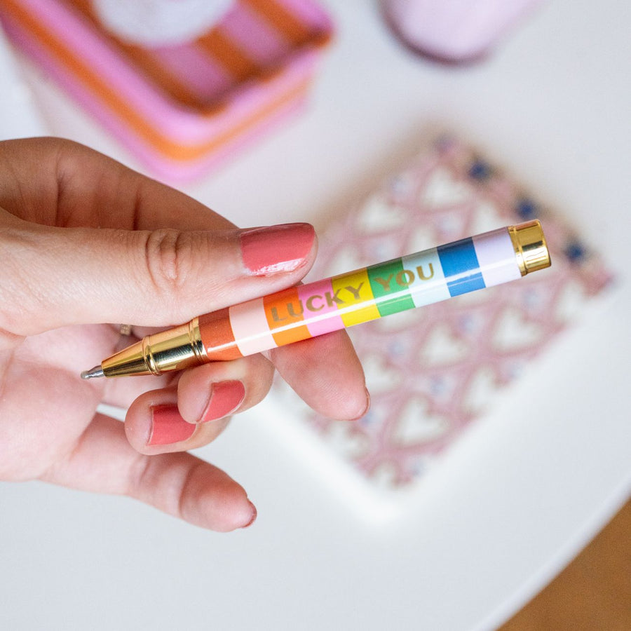 Porte-clé avec stylo rayé et trèfle doré en gros plan