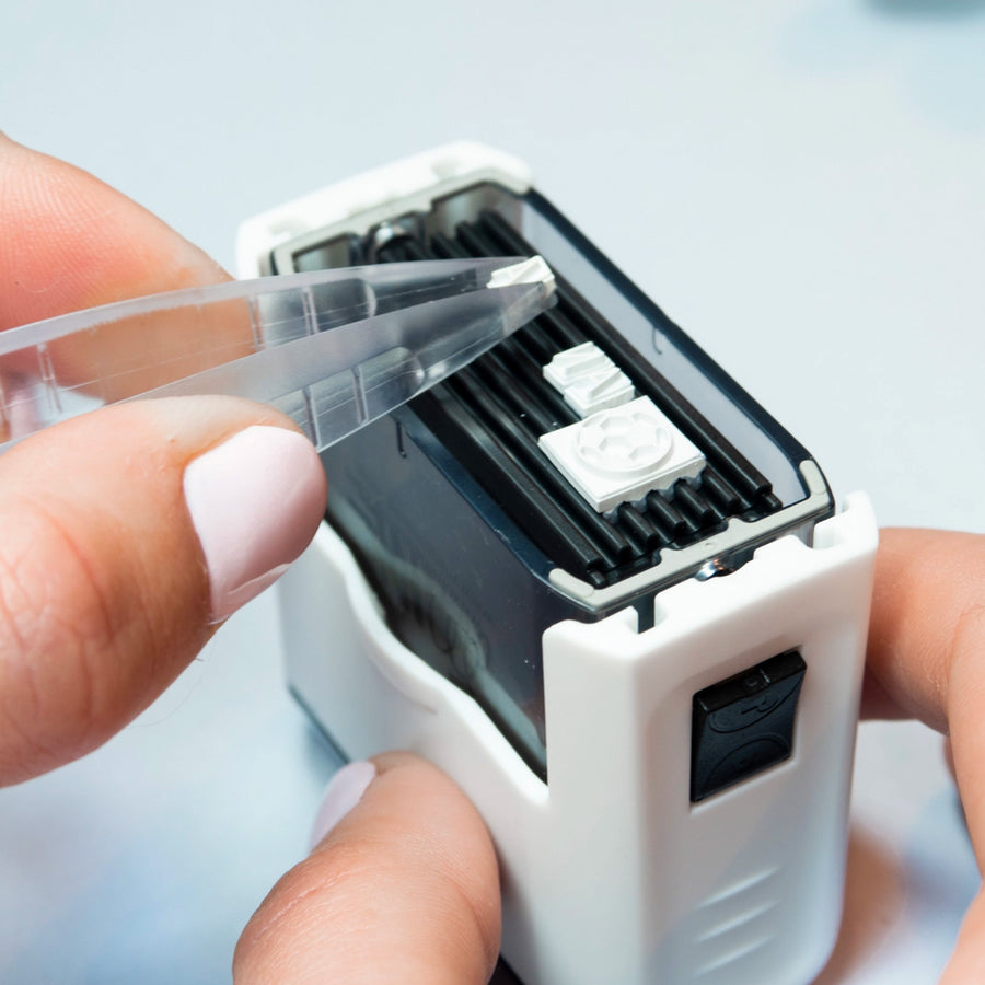 Tampon marqueur textile avec encre visible sur un tissu.