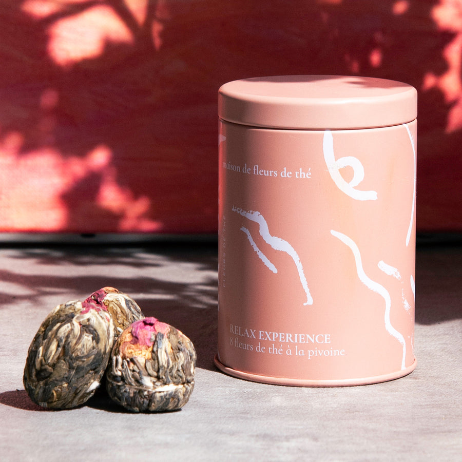 Fleur de thé de pivoine éclose dans une tasse transparente