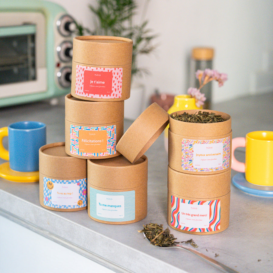 Boîte de thé avec message, vue de face et étiquette colorée.