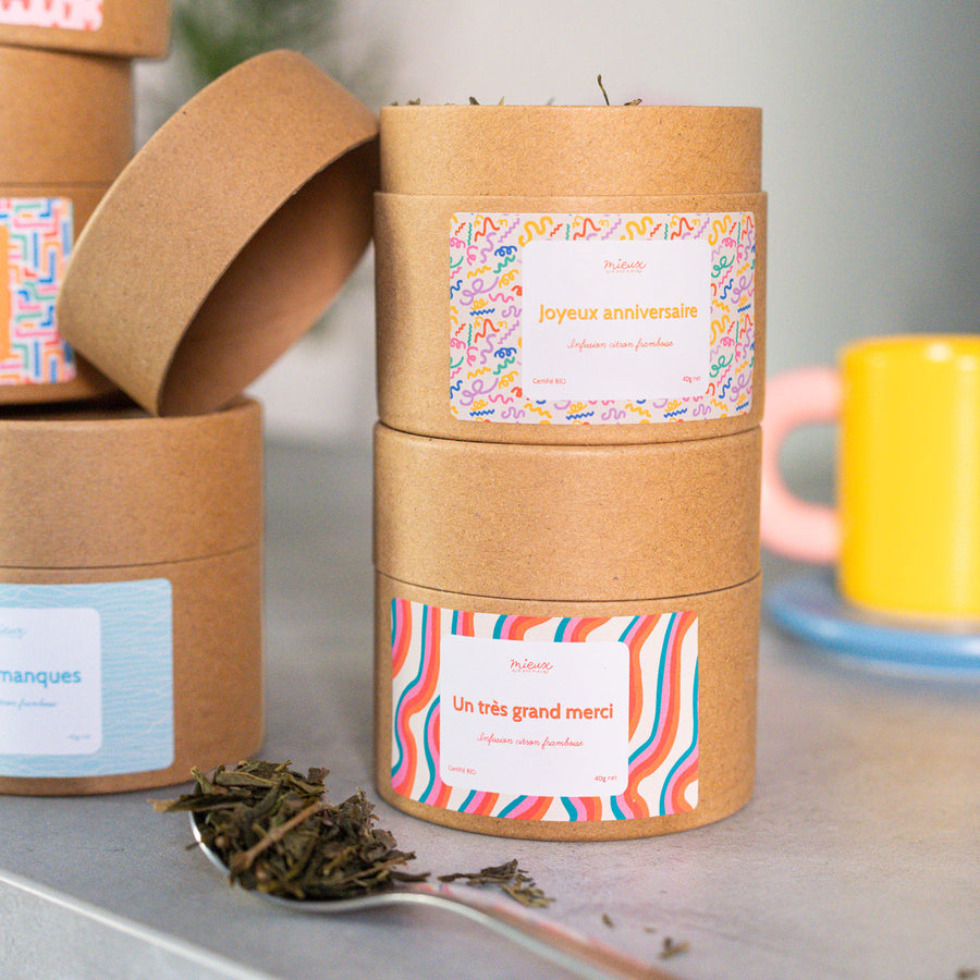 Boîte de thé avec message, vue de face et étiquette colorée.