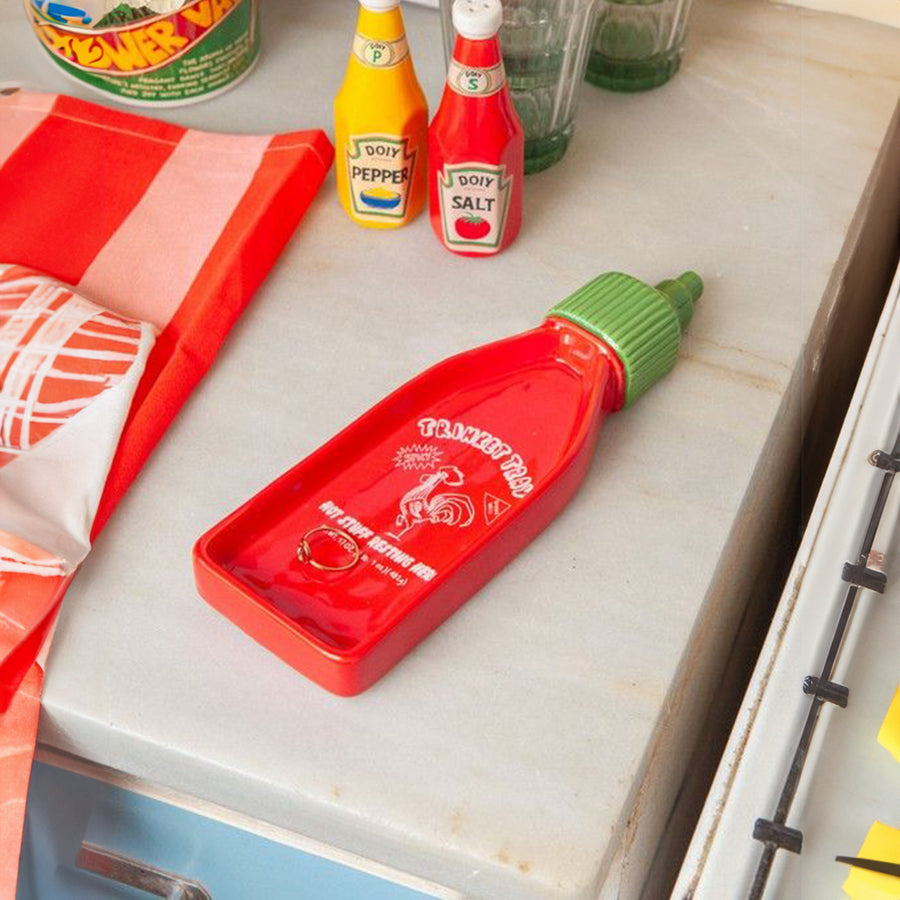 Vide-poche en forme de bouteille Sriracha avec détails colorés.