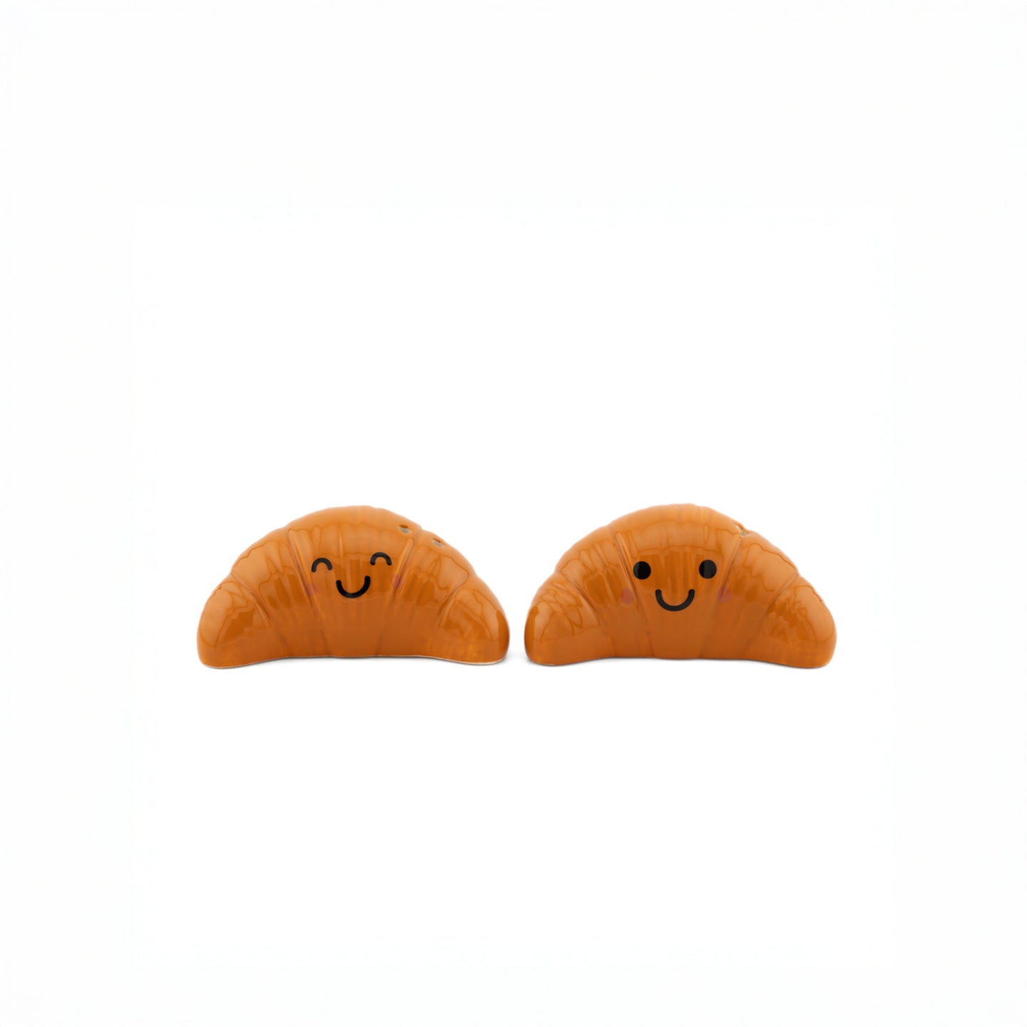 Salière et poivrière en forme de croissants sur fond clair