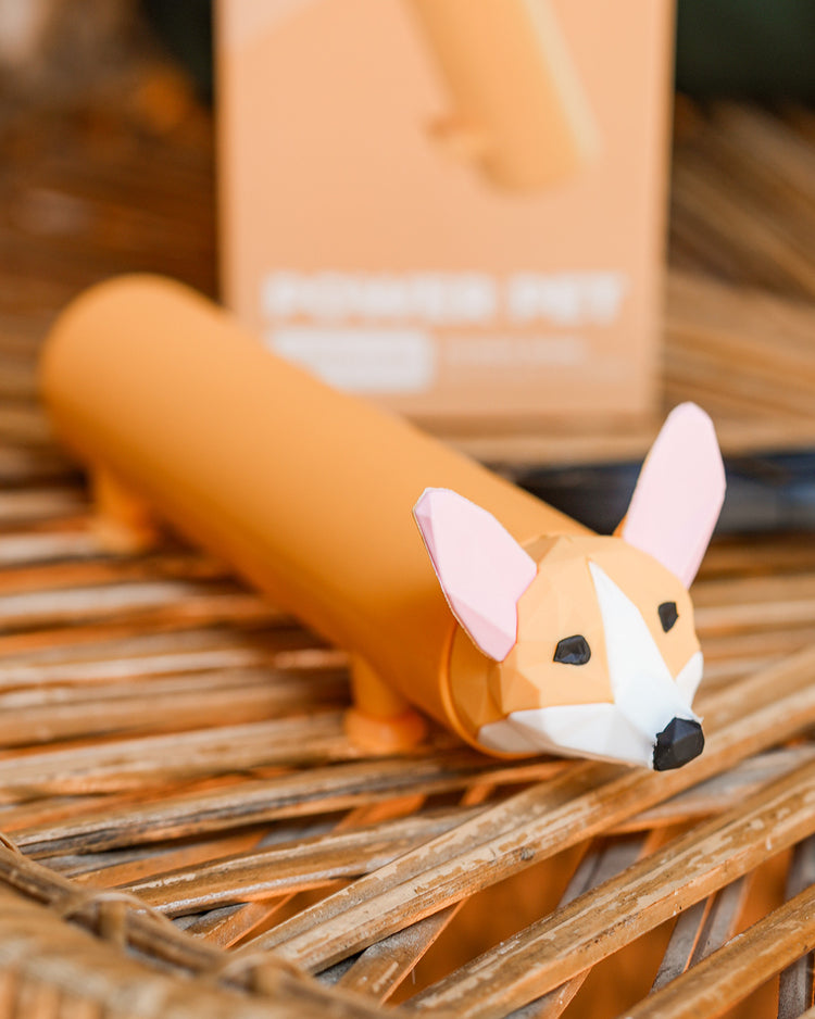 Batterie externe en forme de Corgi avec pattes ventouses.