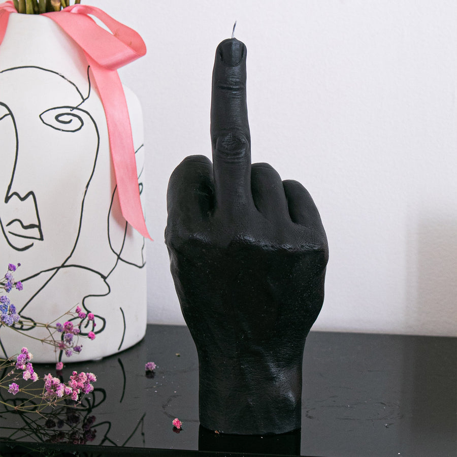 Bougie en forme de doigt d'honneur sur fond neutre