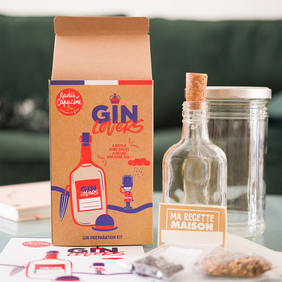Kit DIY pour gin avec ingrédients et accessoires sur fond blanc.