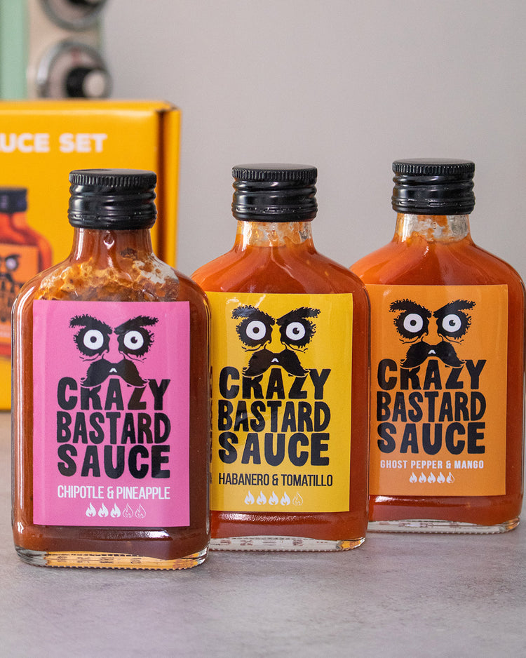 Trois flacons de sauces épicées sur fond blanc.