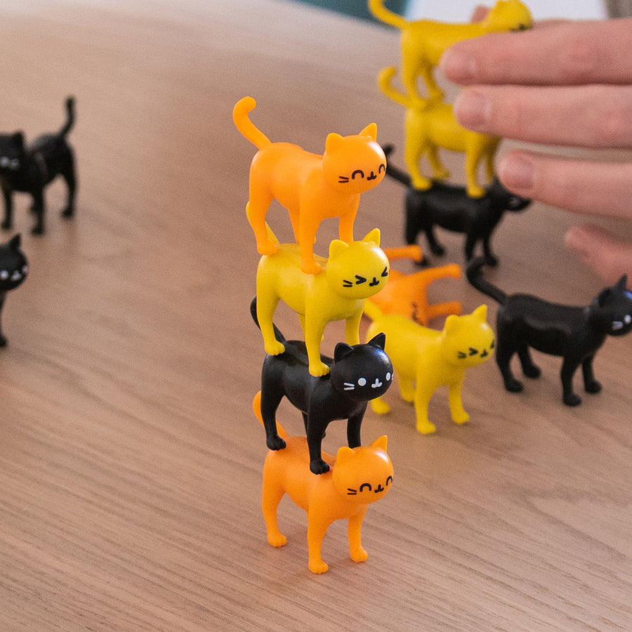 Jeu d'équilibre avec des chats colorés empilés en désordre.