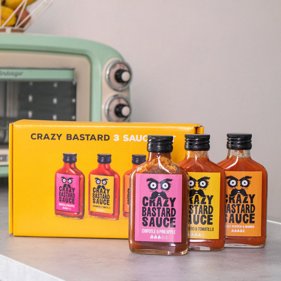 Trois flacons de sauces épicées sur fond blanc