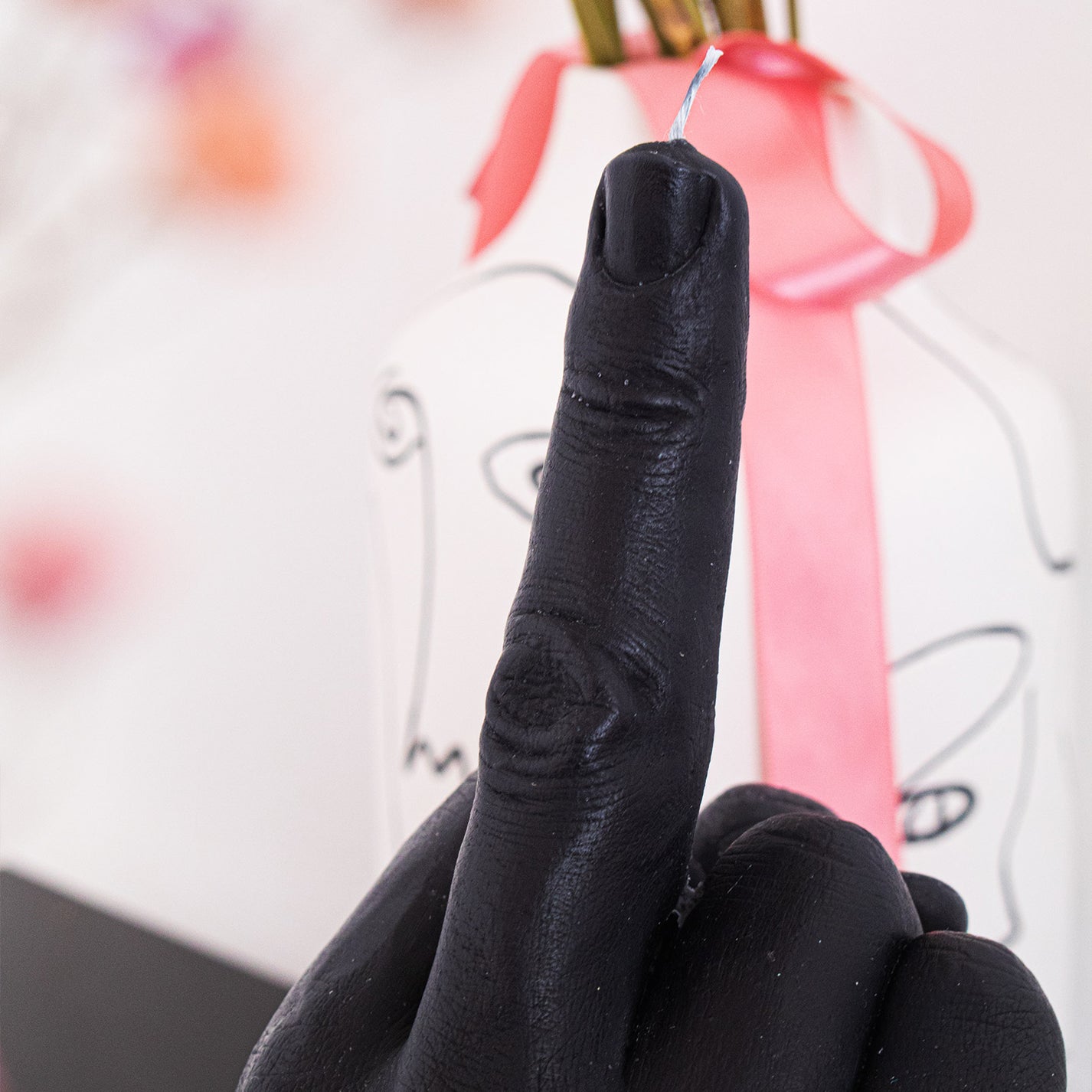Bougie en forme de doigt d'honneur sur fond neutre