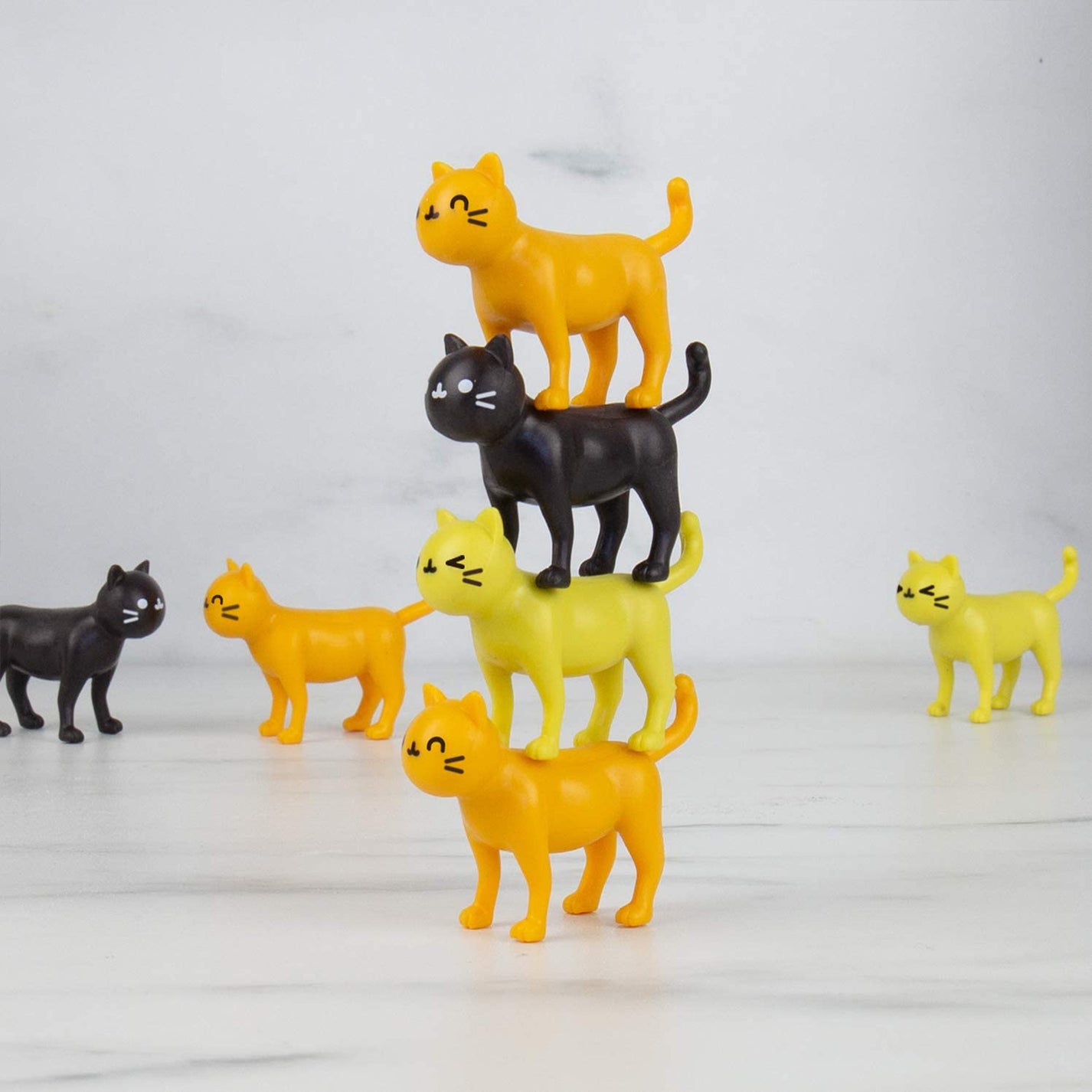 Jeu d'équilibre avec des chats colorés empilés en désordre.