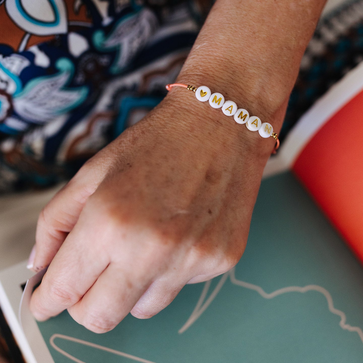 Un bracelet Maman rose et sa pochette en cuir rose gold