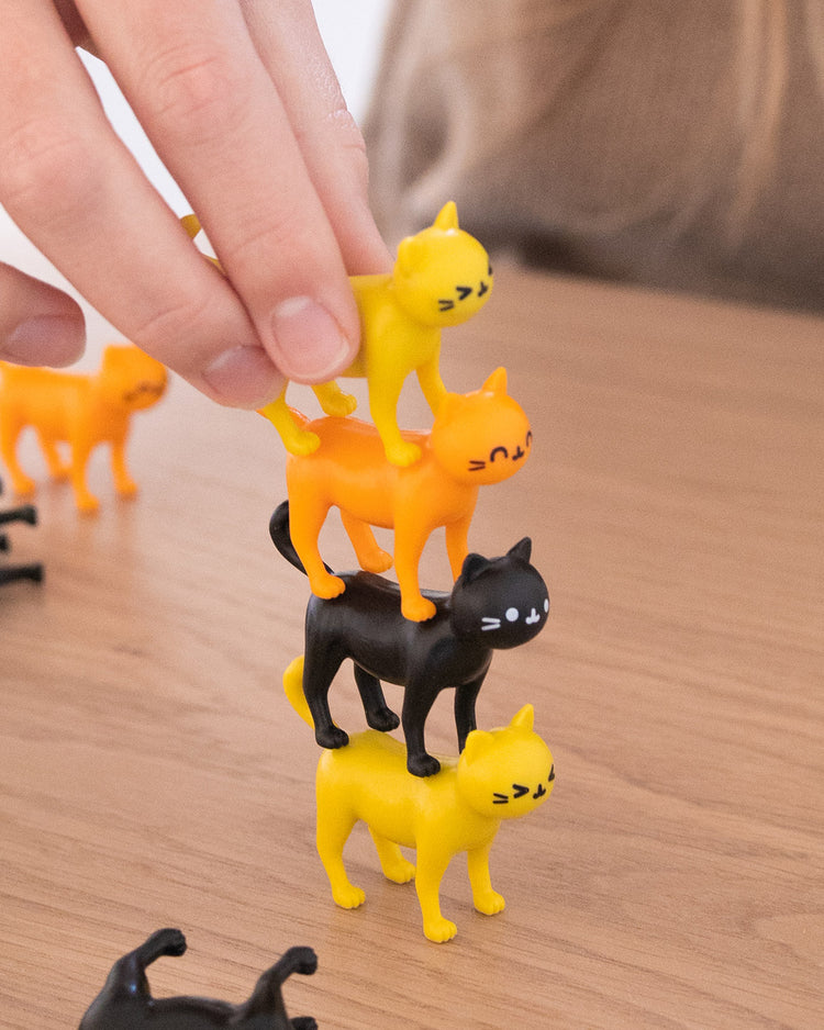 Jeu d'équilibre avec des chats colorés empilés en hauteur.