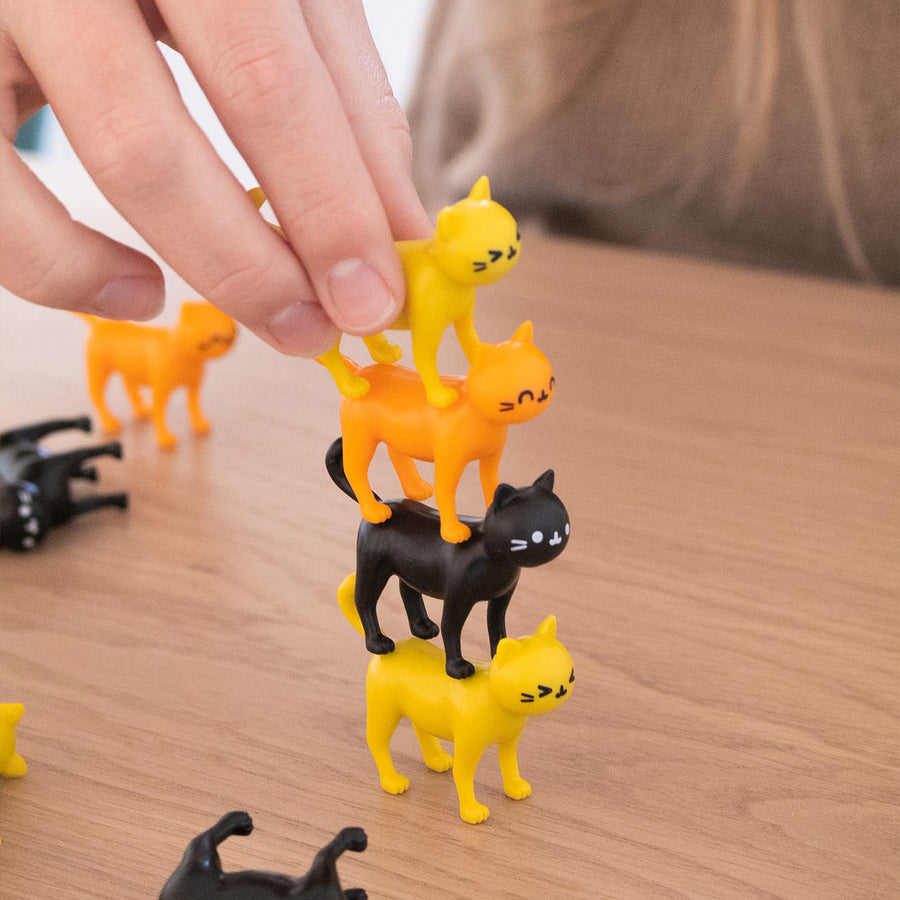 Jeu d'équilibre avec des chats colorés empilés en hauteur.