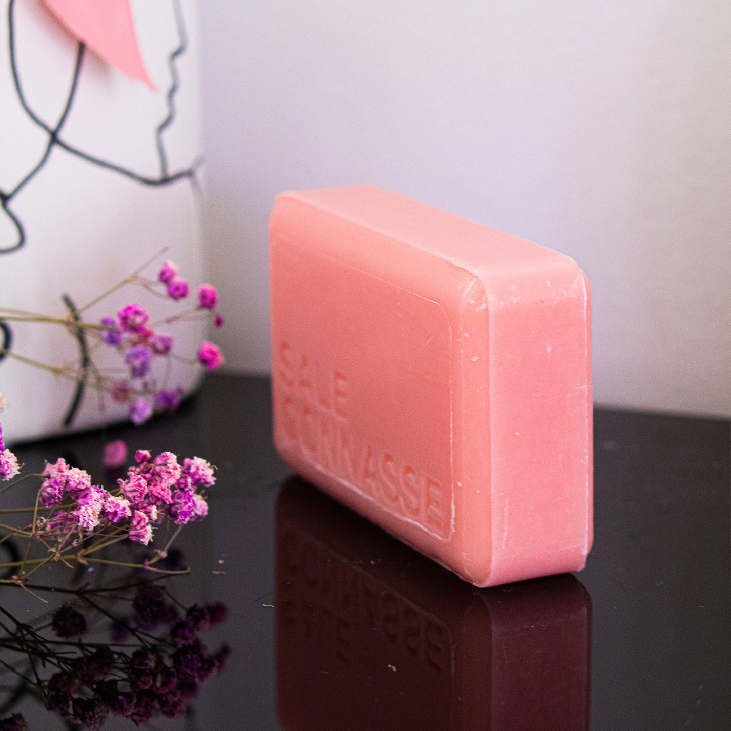 Savon humoristique avec étiquette colorée et motif rose.