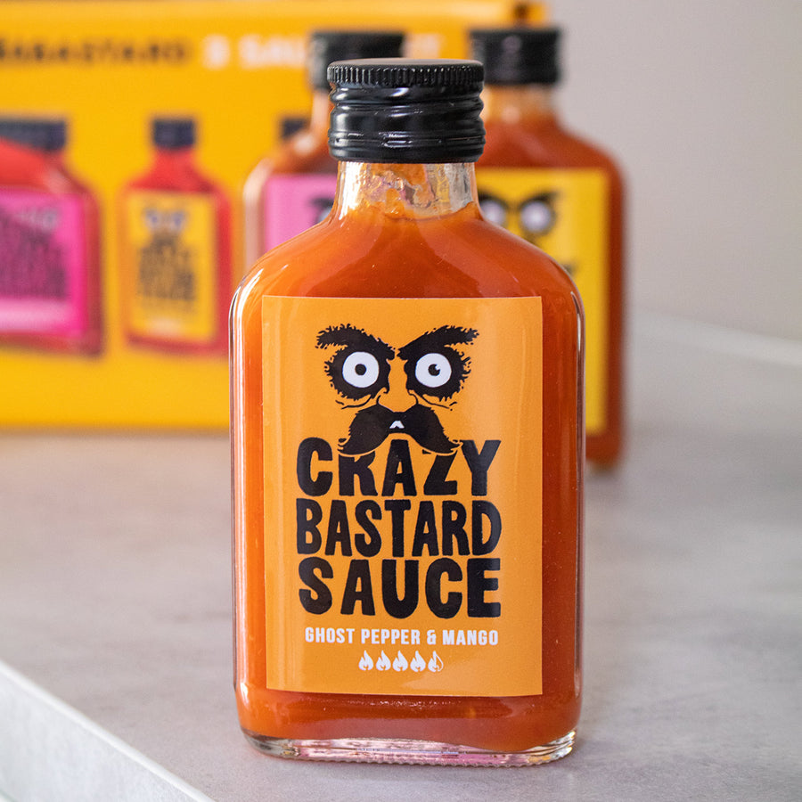 Trois flacons de sauces épicées sur fond blanc