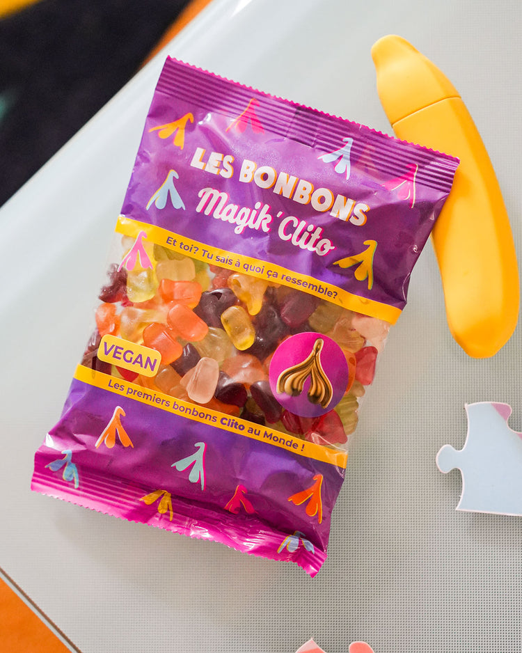 Bonbons en forme de clitoris colorés et sucrés sur fond blanc.
