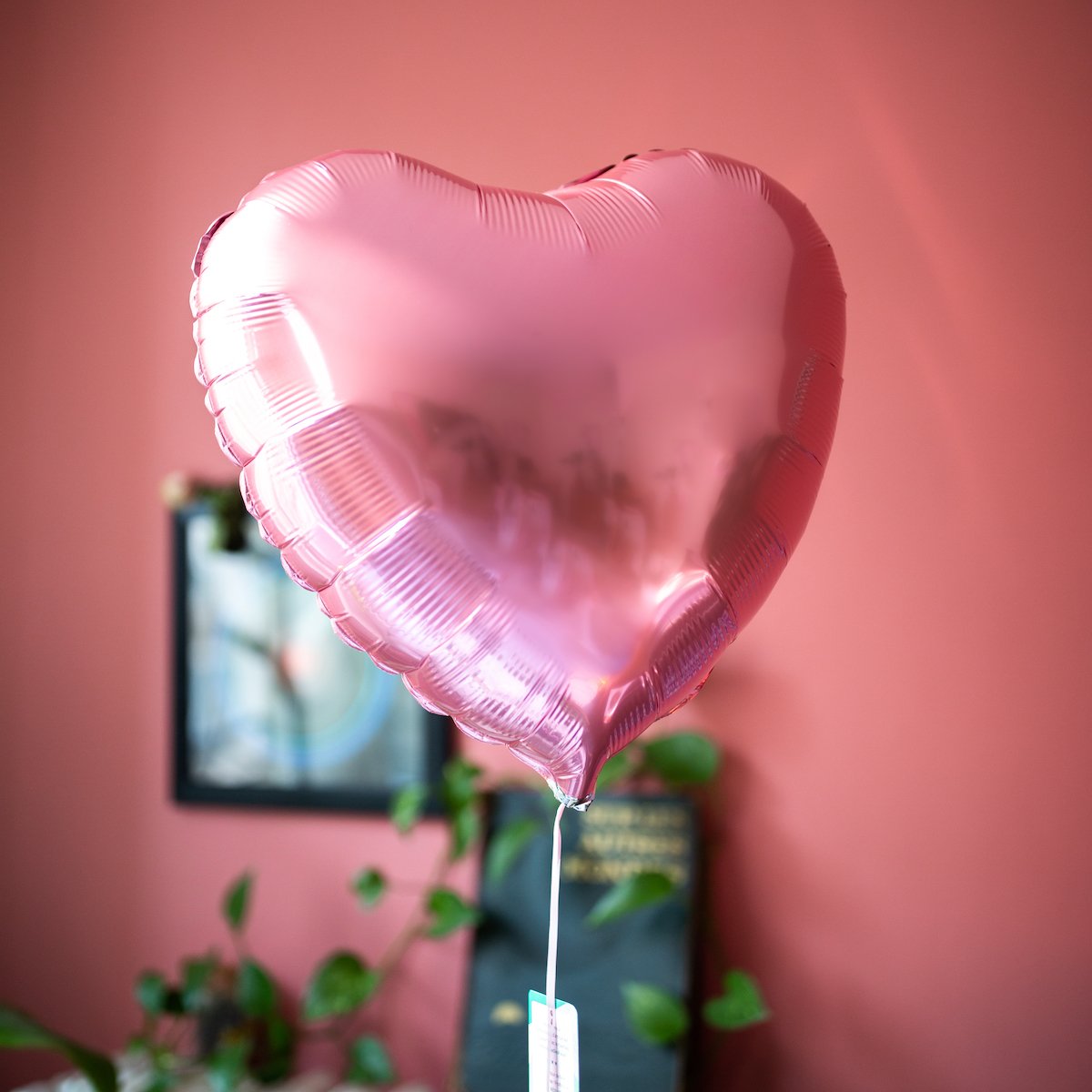 Ballon en forme de cœur rose perle, texture brillante et lisse.
