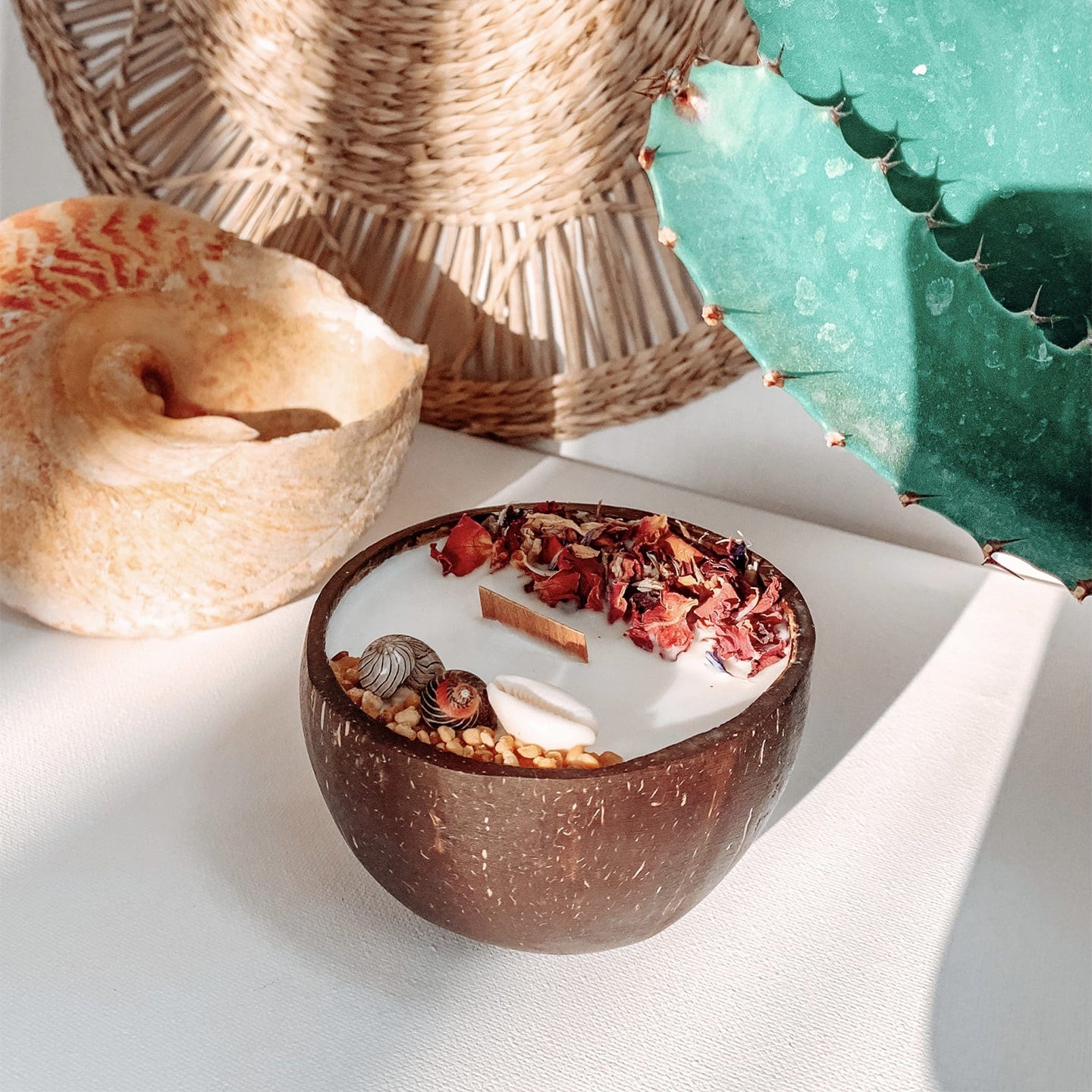 Une bougie monoï dans une noix de coco