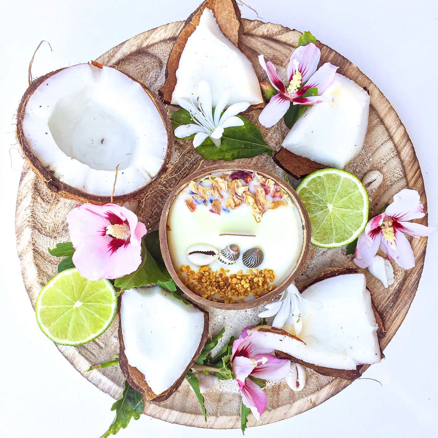 Bougie au monoï dans une noix de coco avec fleurs séchées